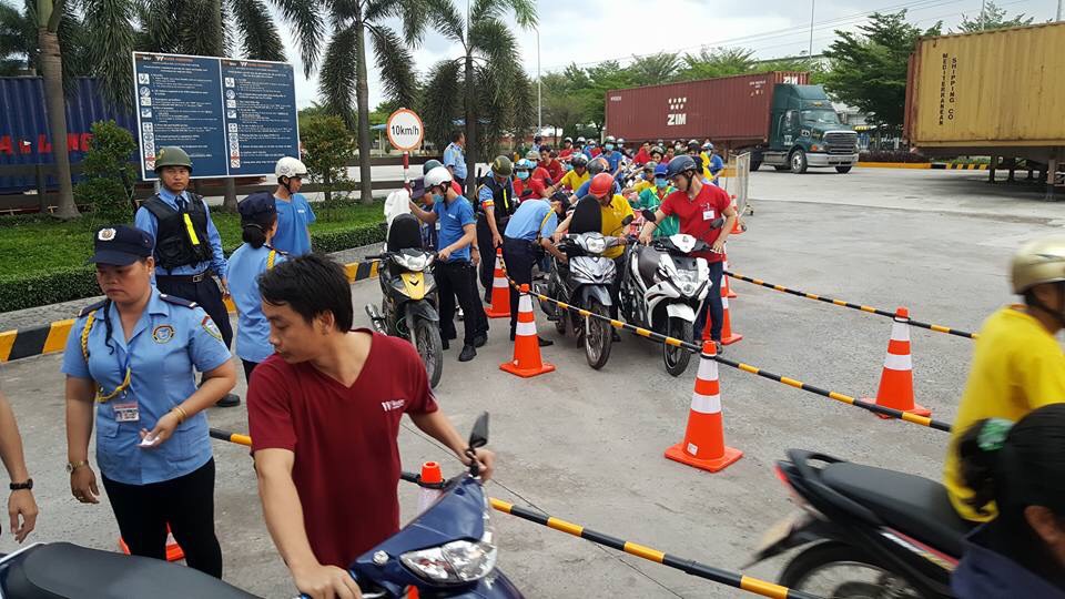 Nhân viên bảo vệ hướng dẫn luồng xe máy tại khu vực ra vào nhà máy